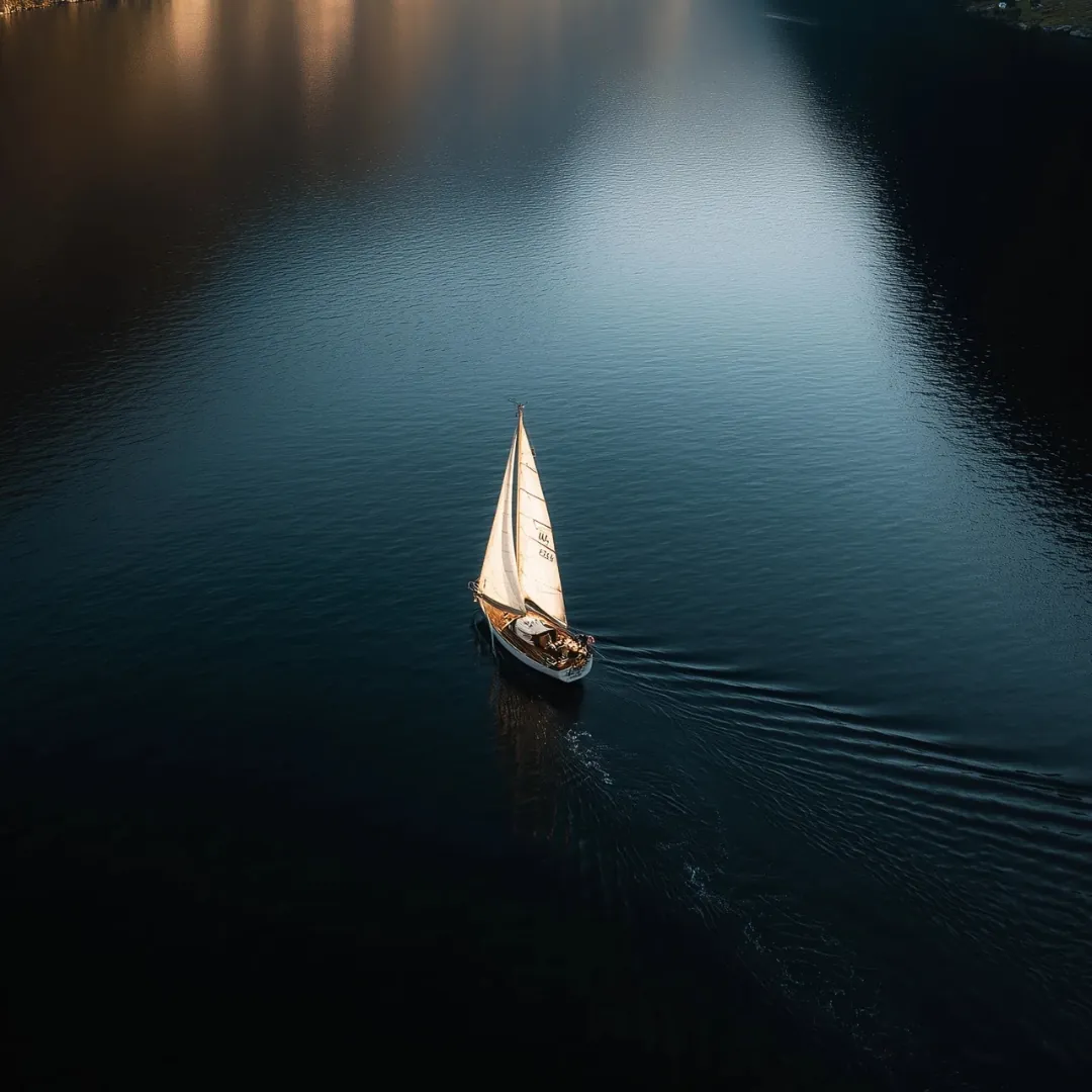 Voilier vu du ciel sur un lac sombre